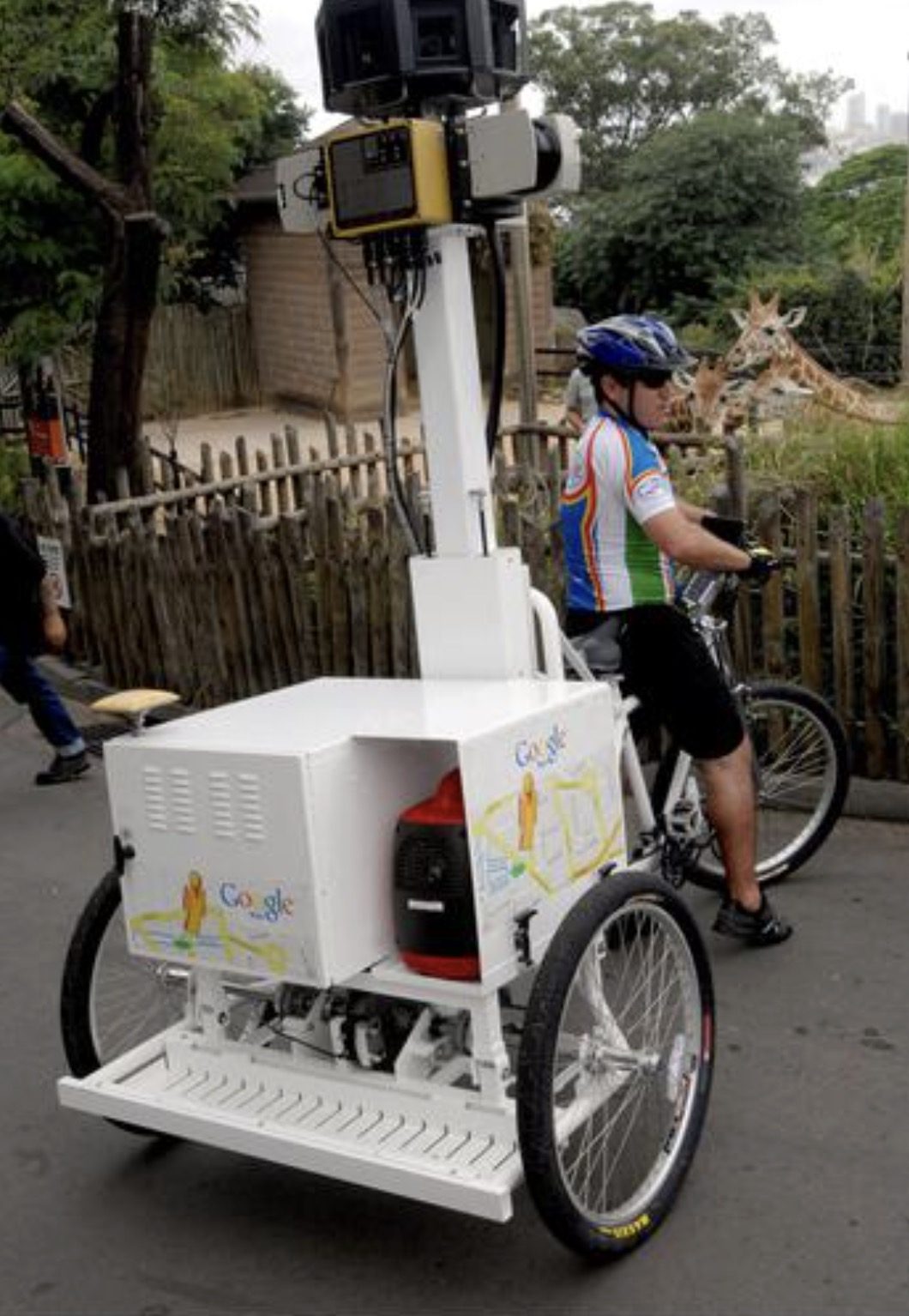 Justin with the Street View trike beside the giraffe enclosure at Taronga Zoo.